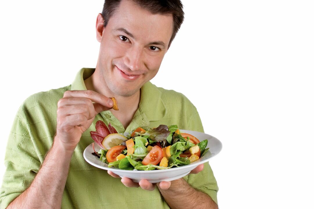 Homem come salada de legumes para ganhar potência